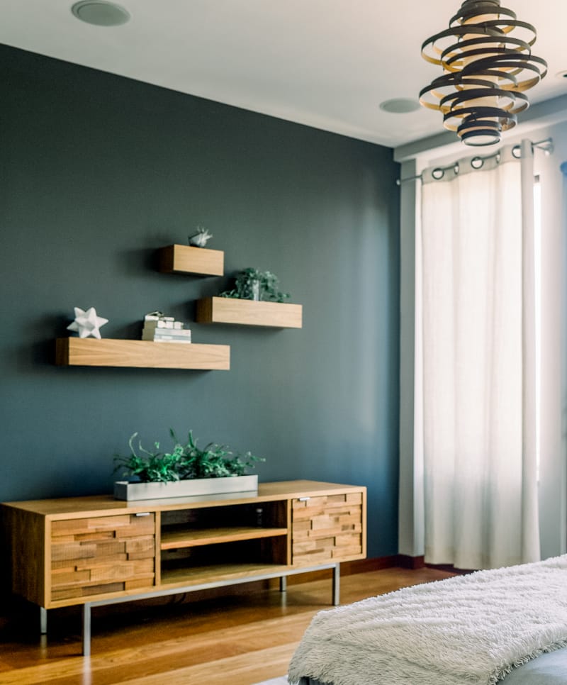 Pared de acento con estanterías flotantes y mueble de madera en diseño de interiores con Home Staging en la Costa del Sol
